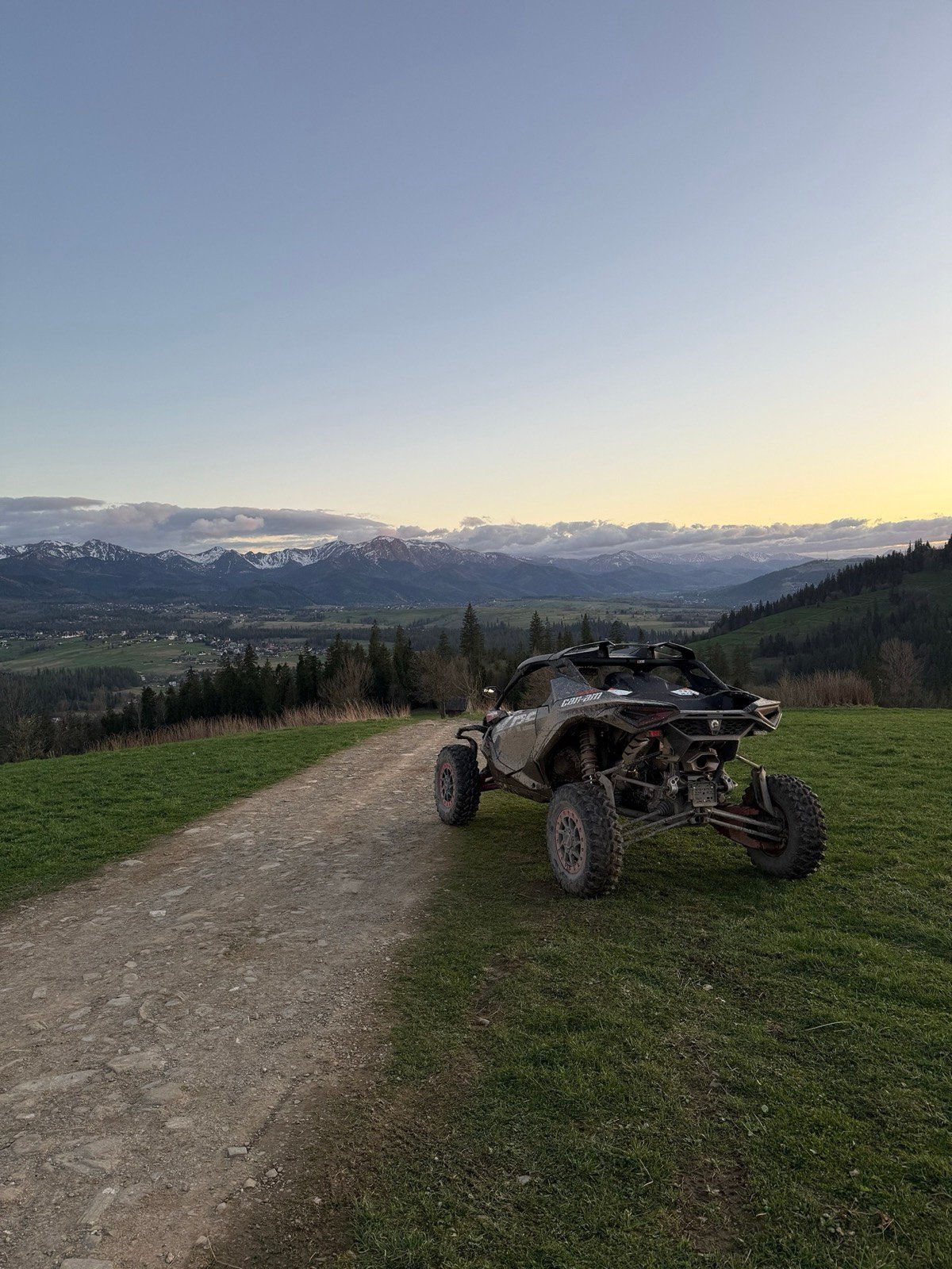 Two buggies on a meadow under a stormy sky with the Tatra ridge on the horizon