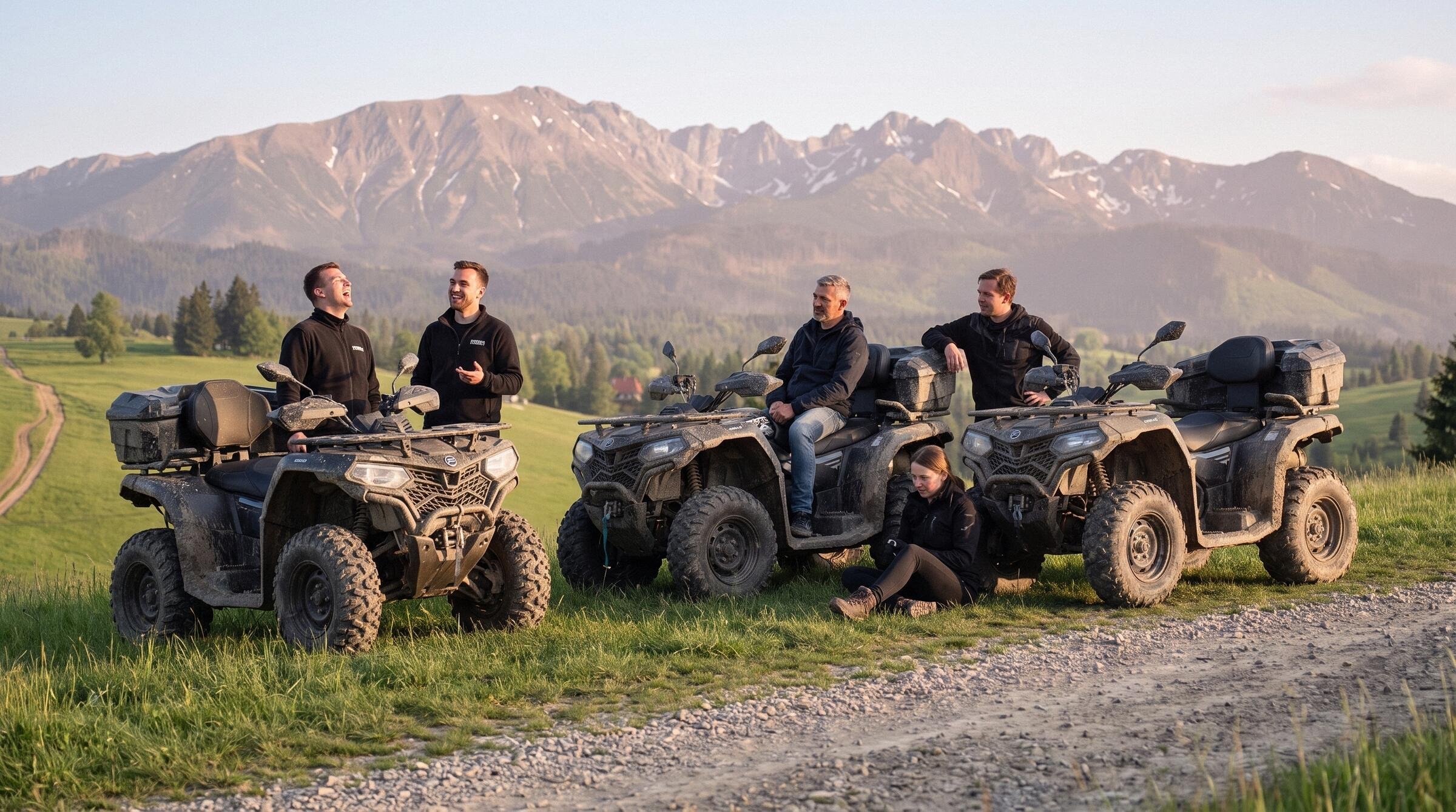Five people resting by three muddy quads above a gravel track at golden hour, the Tatras in warm light behind