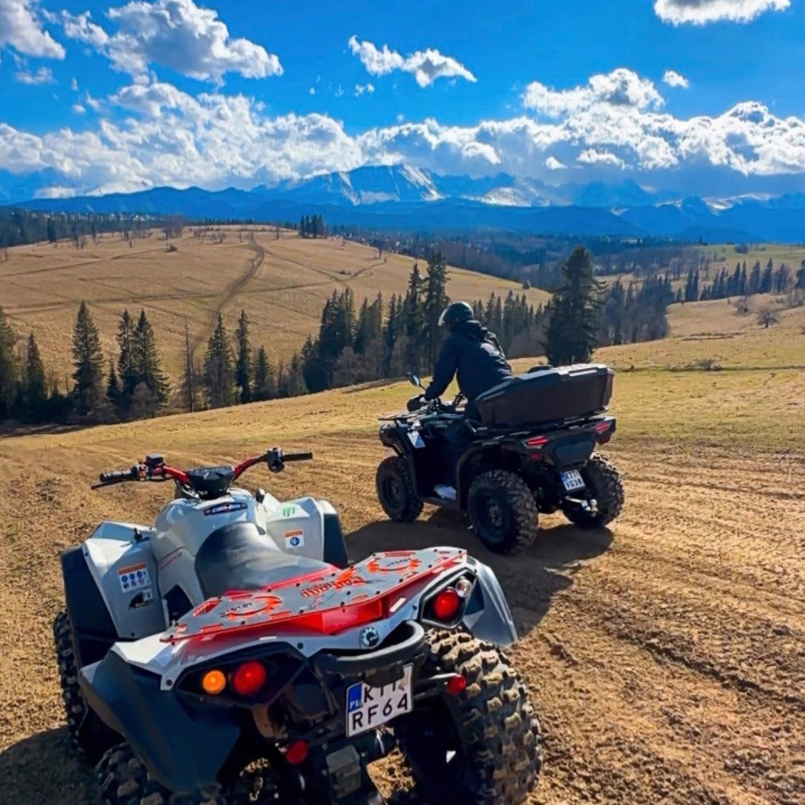 Two quads on an autumn track with a wide view of snow-covered Tatras ahead
